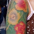 tatuaje en el hombro de flores hibisco en un fondo verde