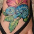 Le tatouage d'hibiscus et de caméléon bleu sur le pied