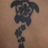 tatuaje de tortuga negra con flores de hibisco