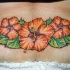 tatuaje en el bajo de la espalda  de la flor de hibisco