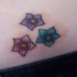 Tre piccoli fiori colorati tatuati
