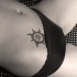 Il sole nero in stile tribale tatuato sulla pancia