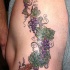 Tatuaje en la cadera, racimo de uvas realistico, multicolor