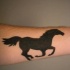 Le tatouage de la silhouette d'un mustang courant