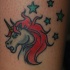 Le tatouage de la tête de licorne rouge avec des étoiles