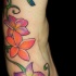 Tatuaje en color la vid con las flores y el colibrí