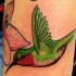 Tatuaje de un colibrí verde volando