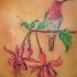 tatuaje de colibrí en exótico árbol