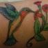 Le tatouage de colibri sur les fleurs rouges