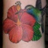 Le tatouage de colibri sur une fleur rouge
