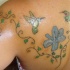 Tatuaje para mujeres de un colibrí y la tracería floral