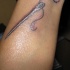 Tatuaje de una aguja con un hilo haciendo el símbolo del infinito