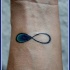 simbolo infinito colorato da un lato tatuaggio