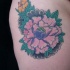 Tatuaje en cadera de flor color rosa verde
