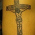 el tatuaje de jesucristo en la cruz hecho en tinta negra