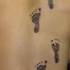 Tatuaje en espalda de huellas infantiles