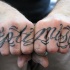 Tatuaje en los nudillos, optimista, letra cursiva con muchos rizos