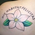 Le tatouage d’inscription Hic habitat felicitas avec une fleur