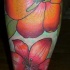 grandi fiori colore arancione sulla gamba tatuaggio