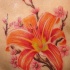 El tatuaje de una flor de Lirio color naranja y flores de sakura