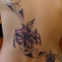 Tatuaje en espalda de lirios y tracerías