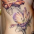 Tatuaje muy elegante en lado de lirios