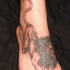 El tatuaje de un leon en el pie