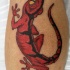 El tatuaje realista de una lagartija de color rojo con ojos de color amarillo