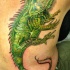 El tatuaje realista de una iguana de color verde en la espalda