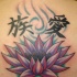 el tatuaje de una flor de loto en estilo chino con jeroglificos hecho en la espalda