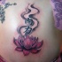 el tatuaje de una flor de loto con jeroglificos en la espalda