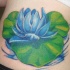 el tatuaje de una flor de loto azul sobre una hoja en el agua