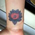 el tatuaje pequeño de una flor de loto con la mantra om  hecho en muñeca
