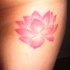 el tatuaje muy tierno de una flor de loto de color rosa