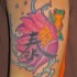 Tatuaje a color un lotus, un heroglifico y una rana