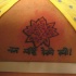 el tatuaje pequeño de una flor de loto con unas palabras en hindu
