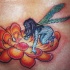 el tatuaje de una flor de lot de color naranja con una hada azul