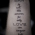 el tatuaje de un texto sobre la guerra y el amor hecho en cursivo en la mano