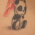 Pequeño tatuaje en bajo de la espalda con panda decepcionado bajo paraguas