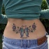 Tatuaggio colorato sulla lombo : la farfalla & i fiori & 