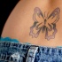 Tatuaje en el bajo de la espalda, mariposa en tinta morada