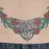 Tatuaje en el bajo de la espalda, tracería con flores en color