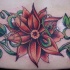 Le tatouage de bas du dos avec une belle fleur rouge