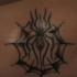 Tatuaje en bajo de la espalda, araña en telaraña, tinta negra y roja