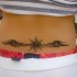 Segno di sole con le disegni tatuati sulla lombo