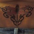 Tatuaje en el bajo de la espalda, libélula con tracería estilo tribal