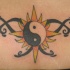 Tatuaje yin yang con sol y estrellas en color en la cintura