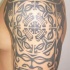 Interesante tatuaje estilo tribal en tinta negra en el hombro