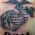 el tatuaje de simbolo de usmc con la palneta tierra ,una ancla y una aguila