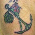el tatuaje de una ancla verde con una rosa e iniciales